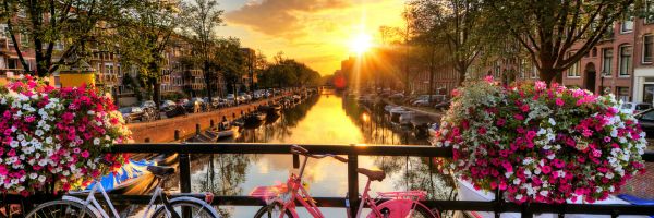 Sunset over canal with bikes in Amsterdam