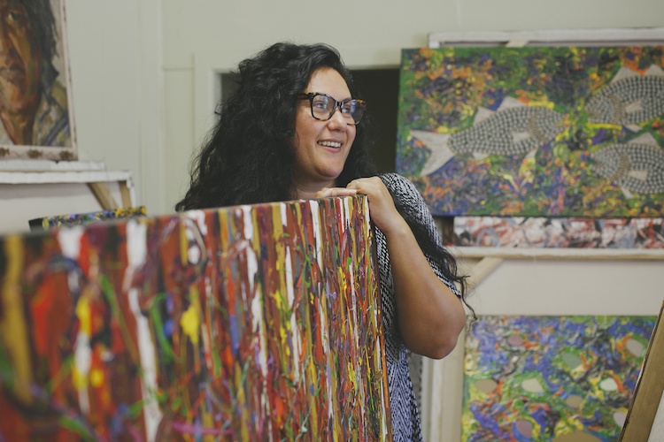 aboriginal artist standing with her work