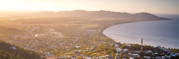 Townhouses stretching along the coastline of Townsville at sunrise